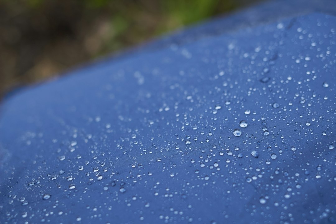 Gotas de agua sobre el tejido de una chaqueta impermeable con tratamiento repelente
