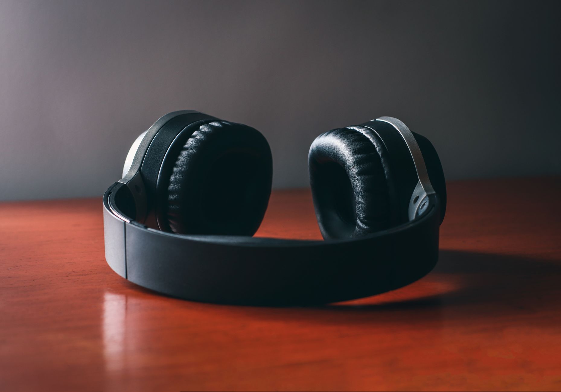 Auriculares inalámbricos de diadema sobre una mesa de madera
