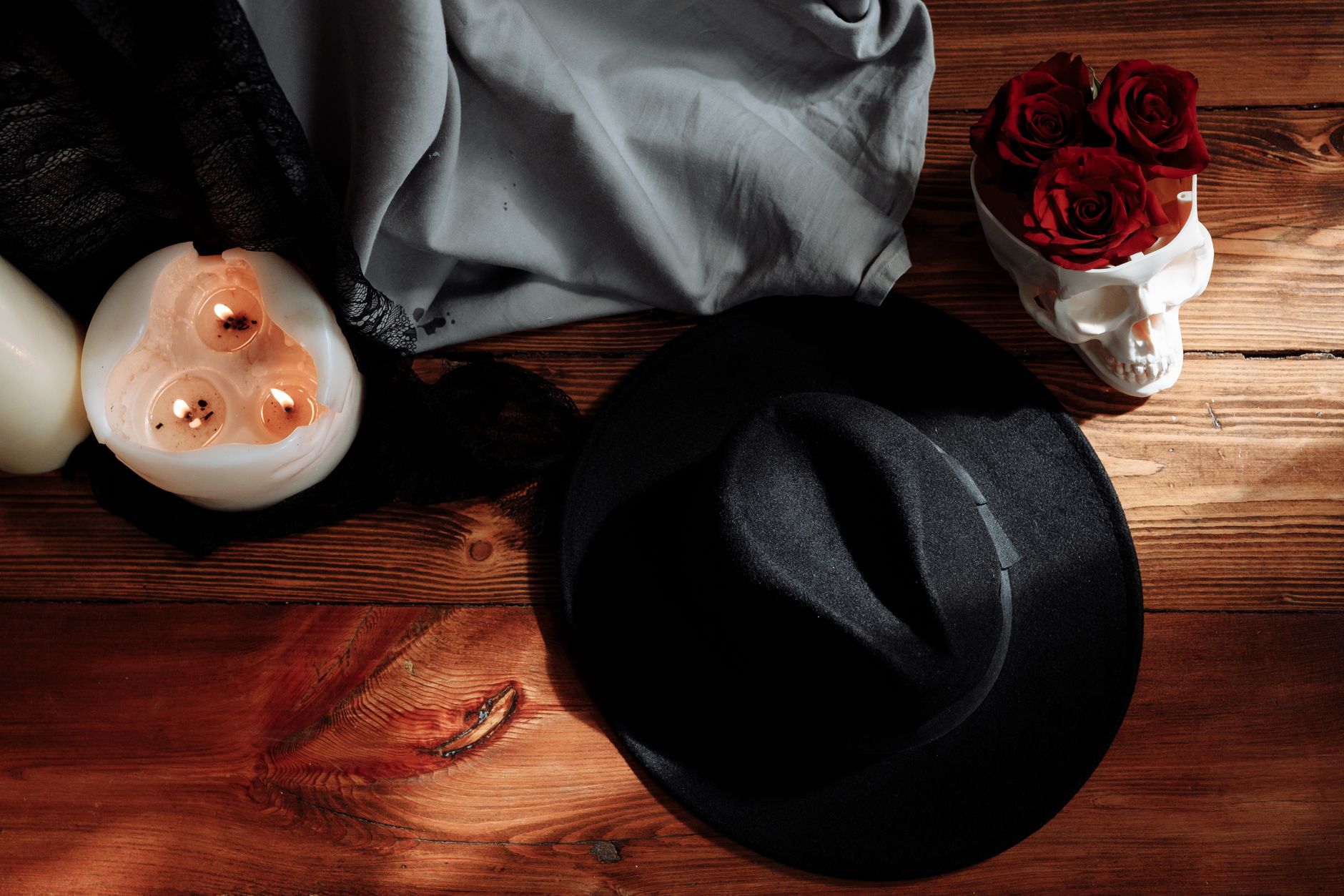 Sombrero negro, vela y calavera decorativa como accesorios para disfraces de Halloween caseros