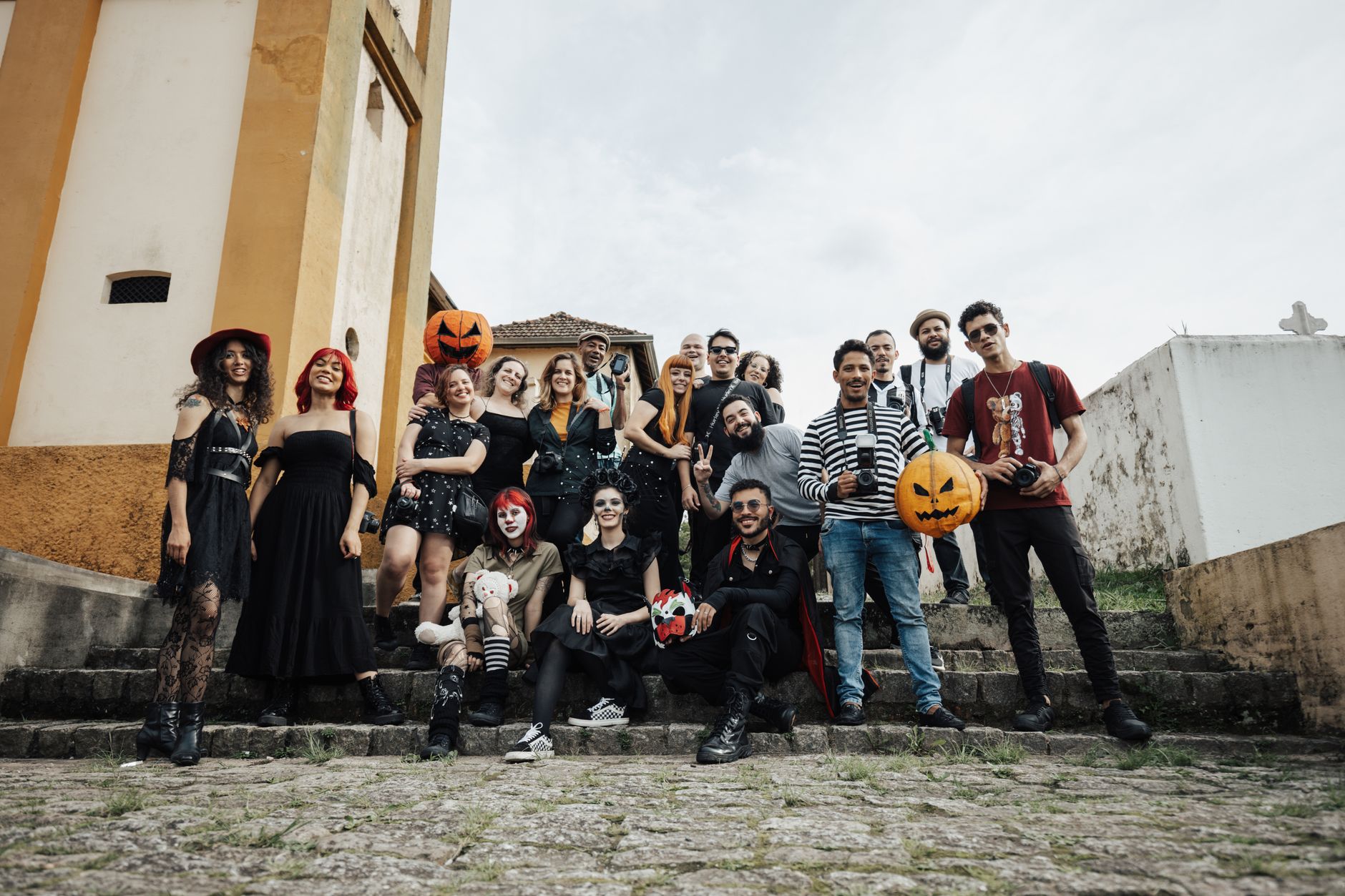 Grupo de amigos con disfraces de Halloween en grupo posando en unas escaleras