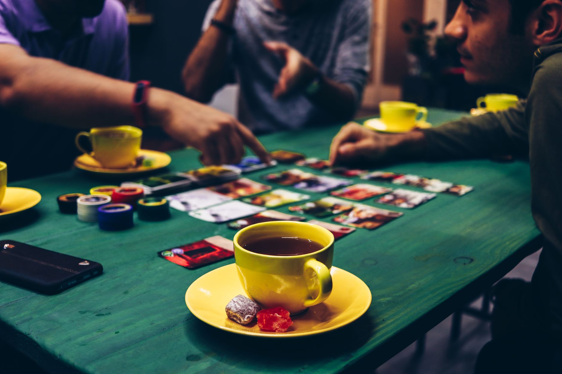 Amigos jugando a un juego de cartas en una fiesta de Halloween en casa