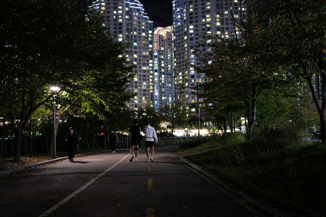 Corredores en un parque urbano de noche con farolas