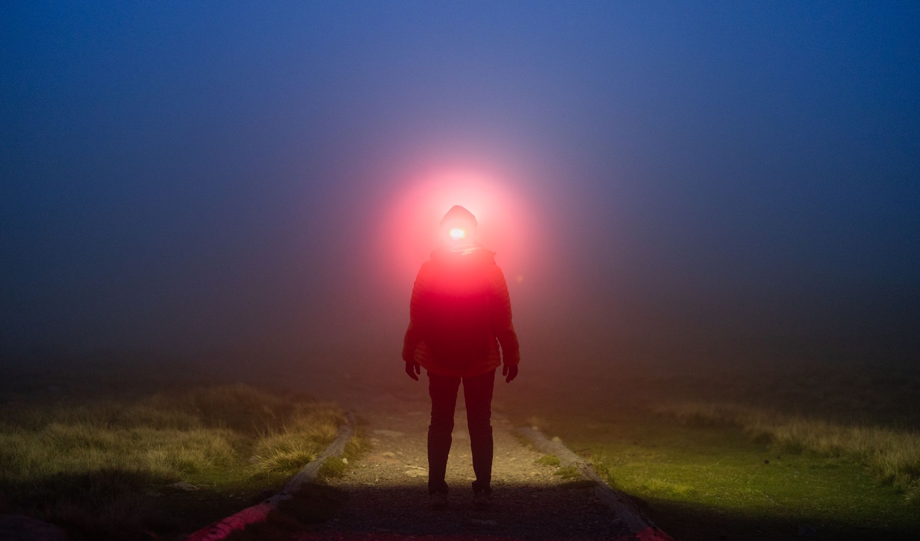 Frontal con luz roja encendida en un camino con niebla