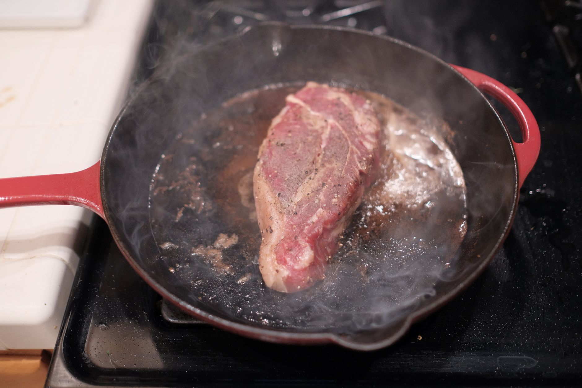 Filete sellándose en una sartén de hierro fundido sobre el fuego