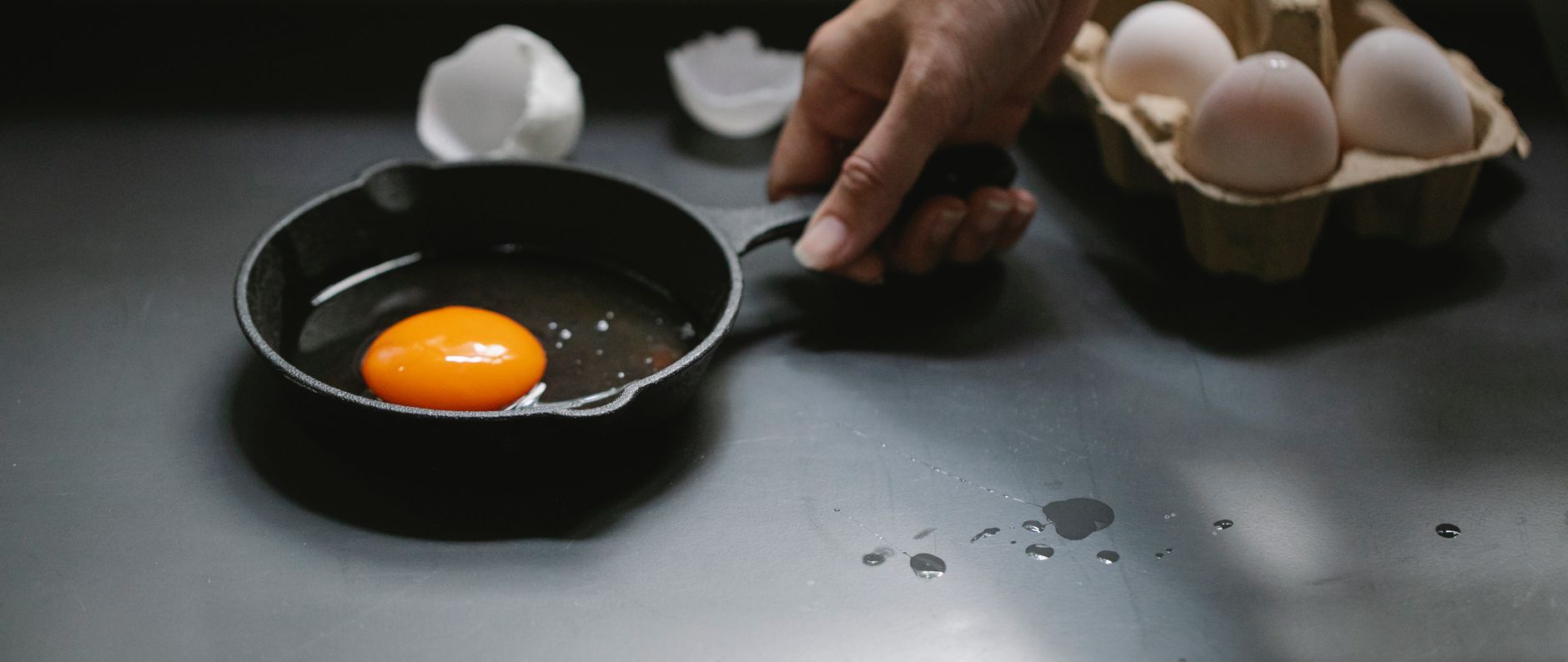 Huevo friéndose en una pequeña sartén de hierro fundido bien curada